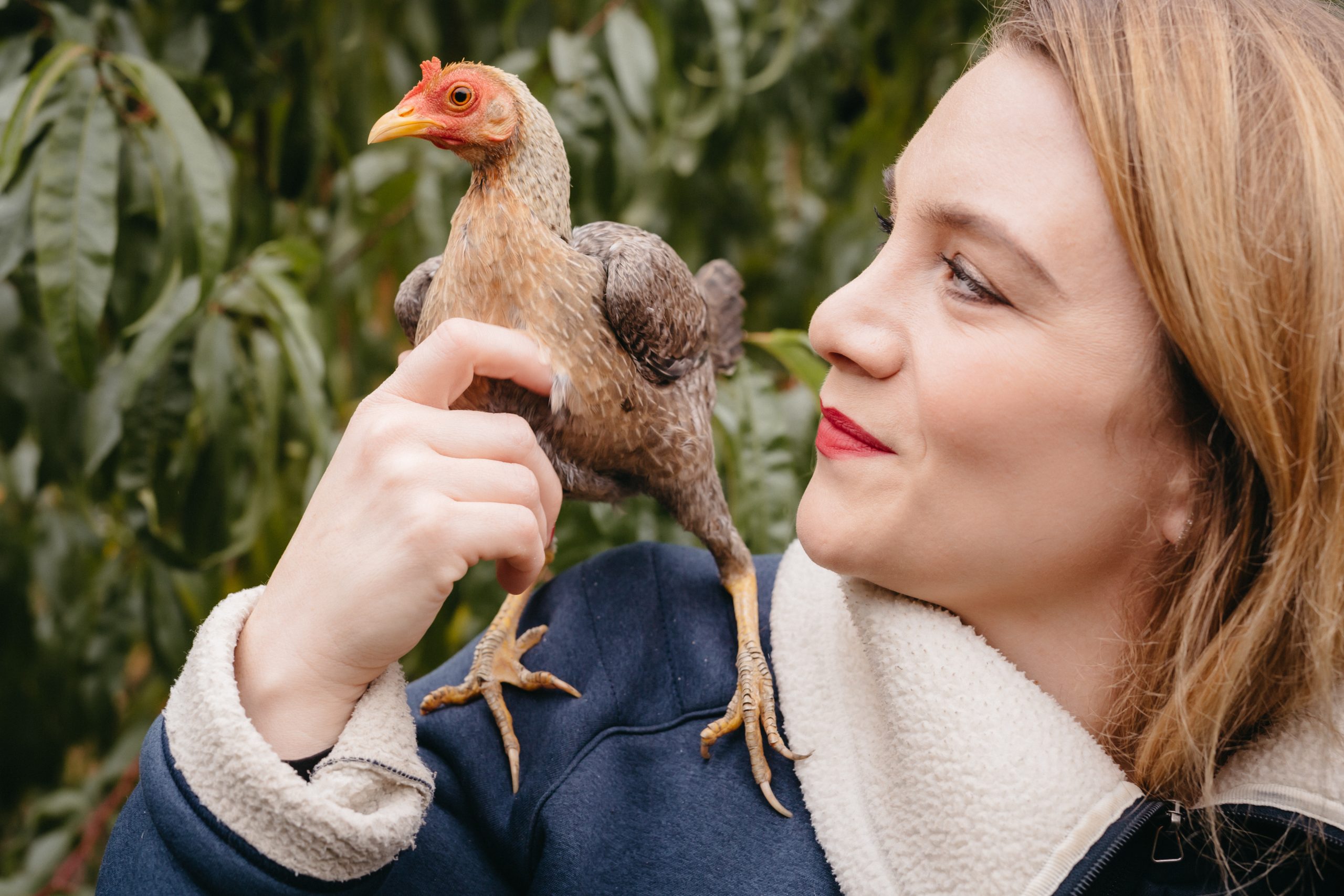 Portrait Swantje Sperling mit Huhn auf der Schulter